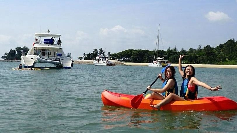 Two happy girls on a kayak near Mikanna yacht